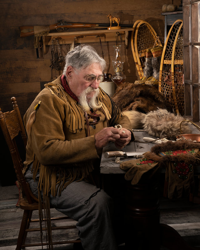 Fur trapper carving bone buttons.