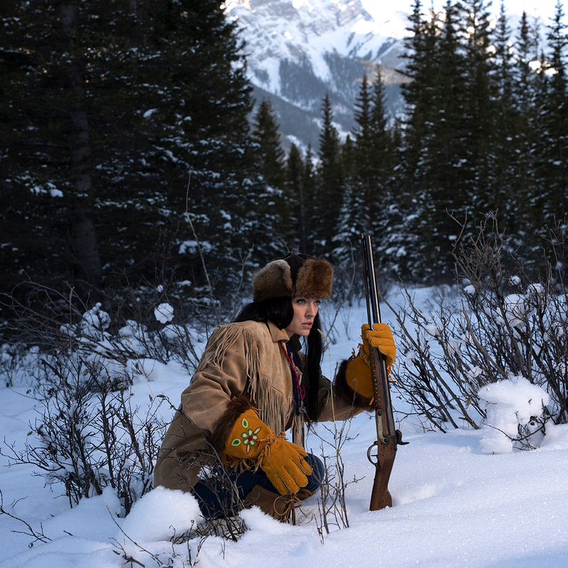 Vintage female hunter tracking game in Rocky Mountains.